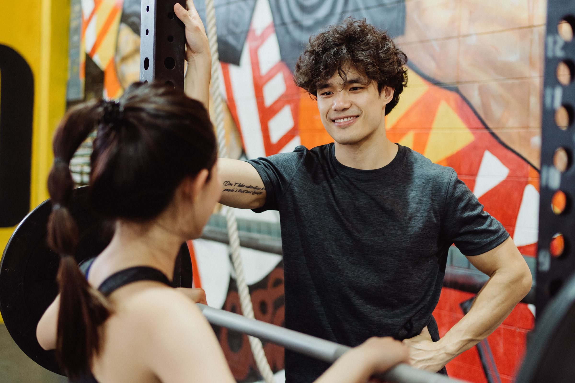 Smiling trainer coaching an athlete in a premium gym